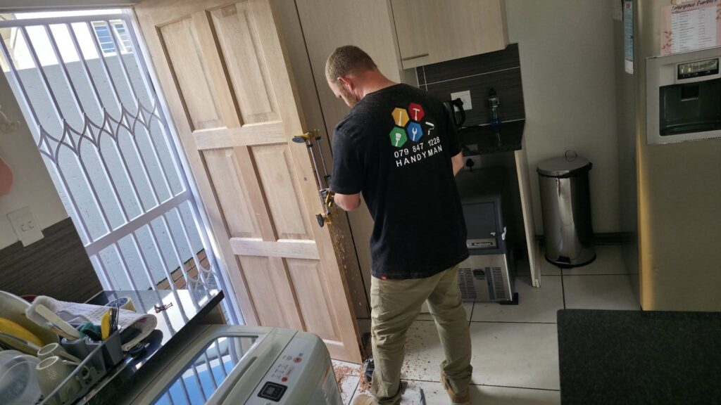 handyman fitting a new door